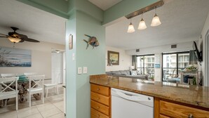 A kitchen with a wooden countertop, white dishwasher, and a dining area with a white table and chairs. - 2 Bedroom, 2 Bath Side Unit with fantastic views of the ocean and pool (Ocean City)