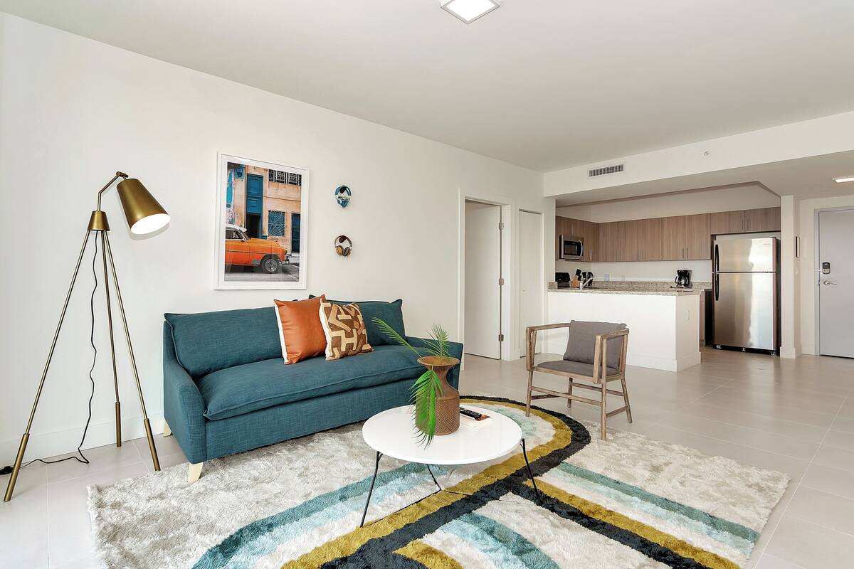 Un salon moderne avec un canapé de couleur turquoise, une table basse et un lampadaire.