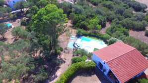 An aerial view of a property with a swimming pool, surrounded by dense greenery and a red-roofed building. - Villa Larco, Private Villa, Pool & Gardens & Stunning Views (Bassacutena)