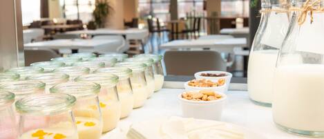 A buffet table with various dairy products, including jars of milk and cheese, and a pitcher of milk.