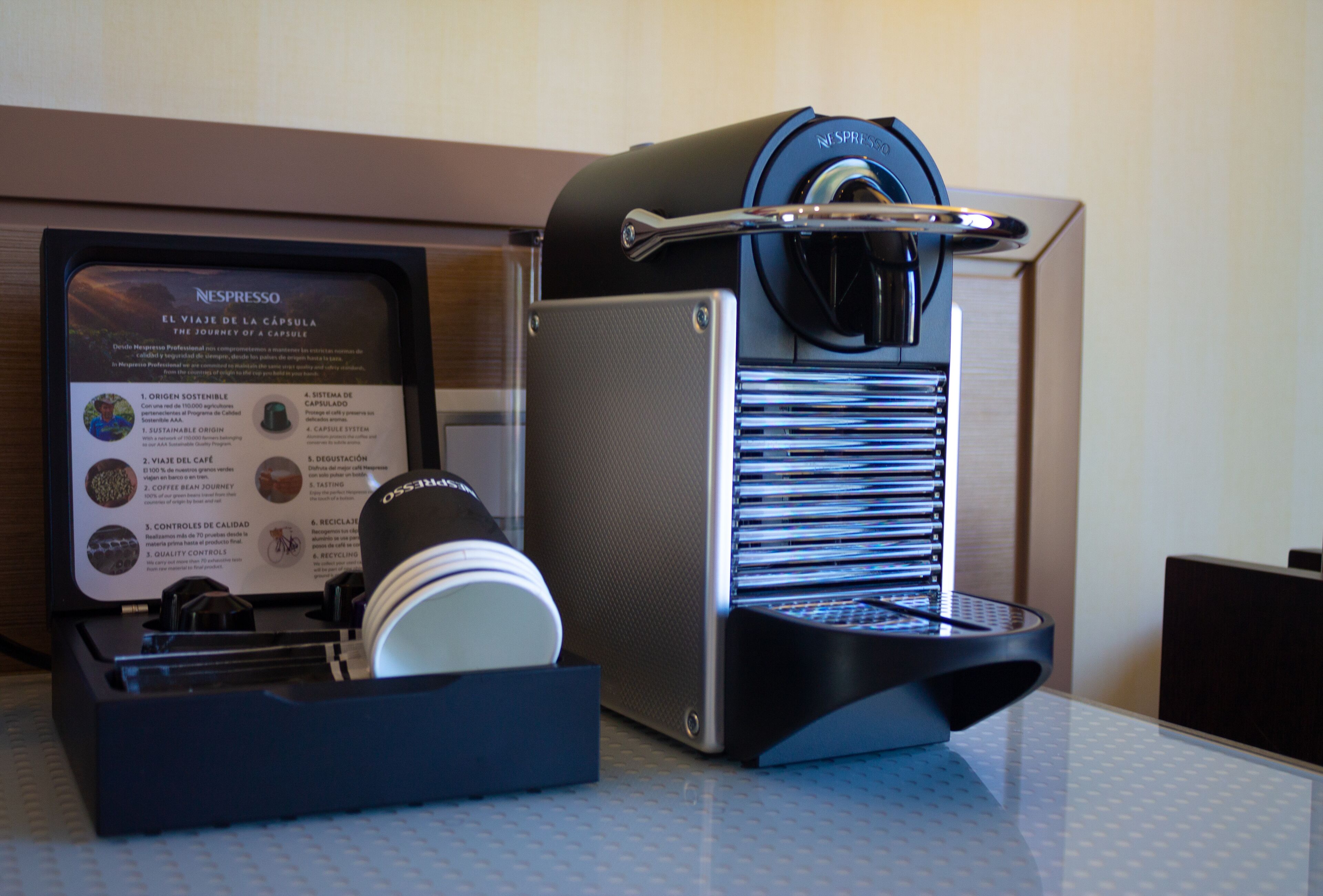 A Nespresso coffee machine with a drip tray and a coffee pod holder.