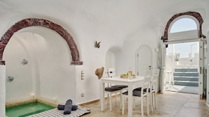 Una habitación con una piscina pequeña, paredes blancas y un comedor con mesa y sillas.