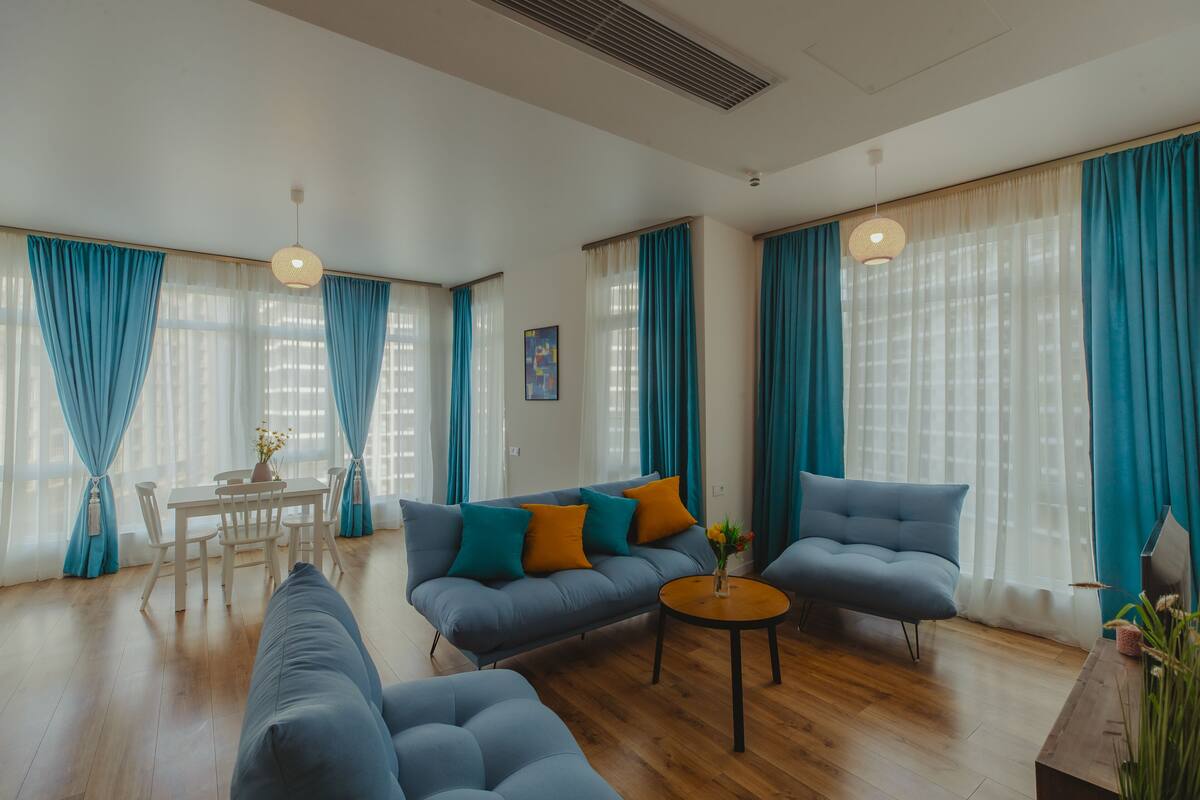 Una sala moderna con sofá, sillón y mesa redonda de centro.