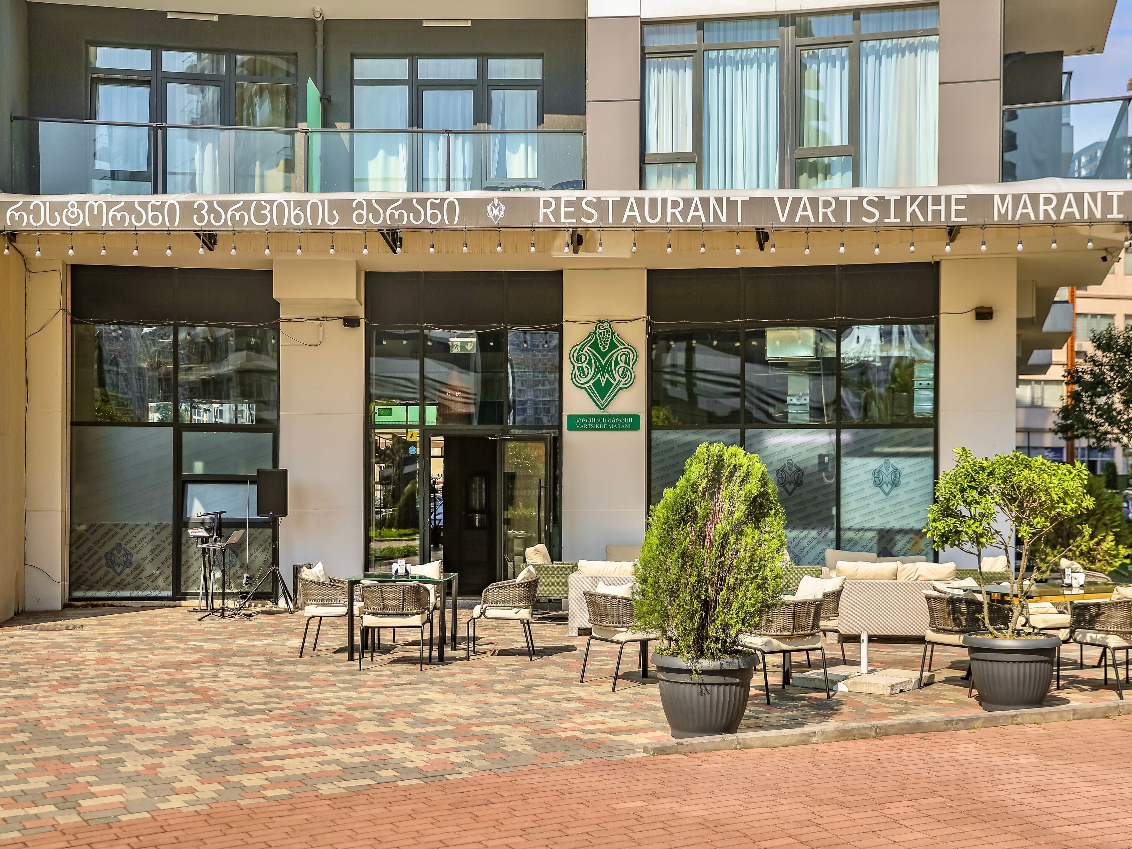A restaurant with outdoor seating and a sign in a foreign language.