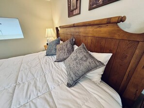 A bed with a wooden headboard, white bedding, and three pillows. - Fox Run | 3BR Near Wolf Creek + Free Activities (Mesquite)