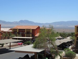 A residential area with houses, a parking lot, and mountains in the background.