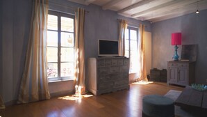 A room with wooden flooring, a dresser, a television, and a lamp. - La Maison d'à Côté (Taillebourg)