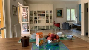 A dining area with a glass table, a bowl of fruit, and a juice carton. - Flatty Alassio - Aloe (Alassio)