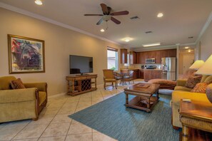 A living room with a television, seating, a dining area, kitchen, and a ceiling fan. - Fantastic Reflection Lakes Pool Home with Fabulous Views in Naples, Florida! (Naples)