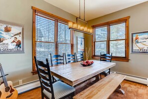 A dining area with a wooden table, chairs, and a guitar.