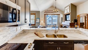 A modern kitchen with a large island, built-in appliances, and a view to the living area. - Walk to Lift | Heart of Main St | Pool | Hot Tubs! (Breckenridge)