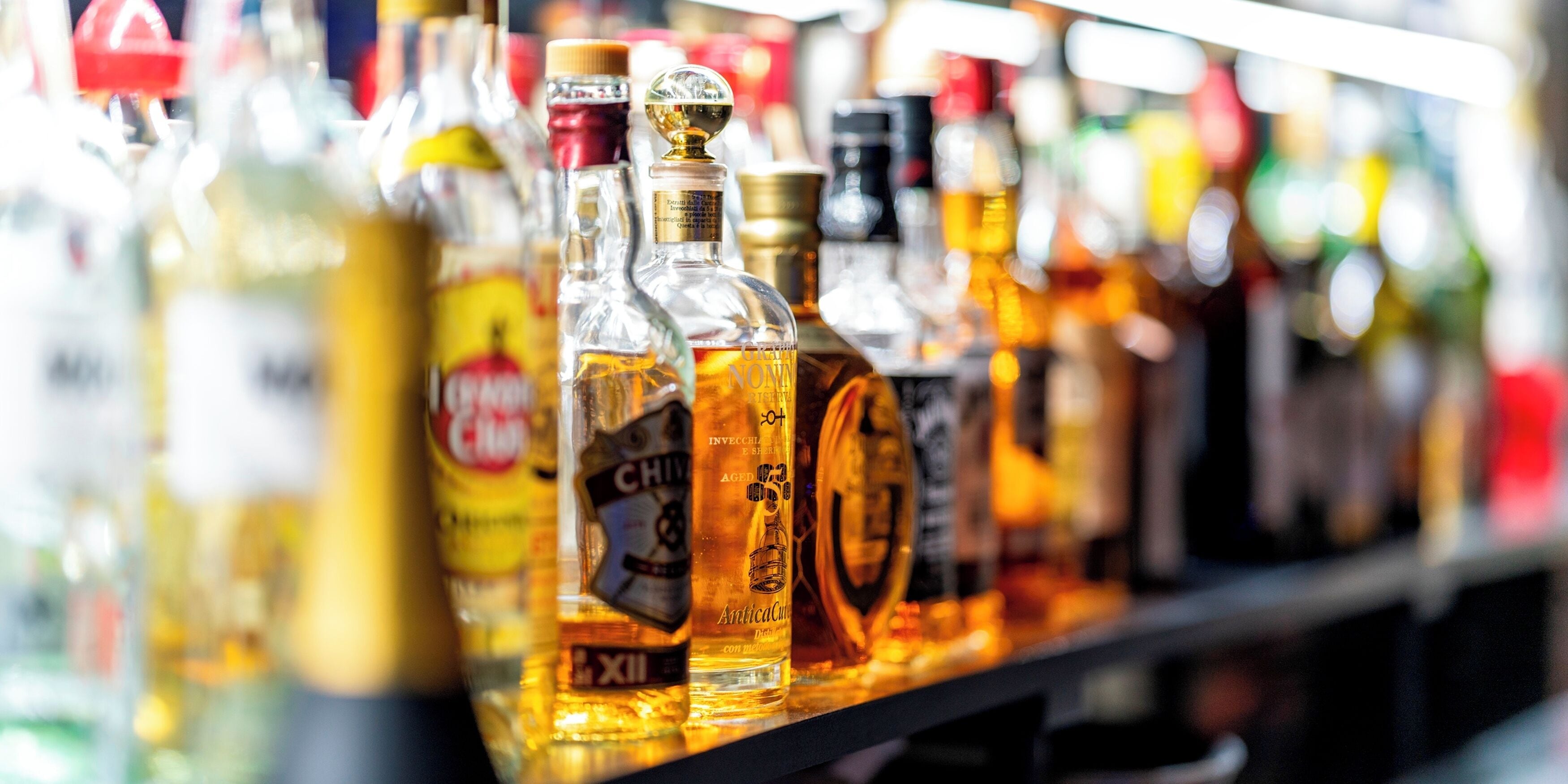 A variety of liquor bottles on a shelf.