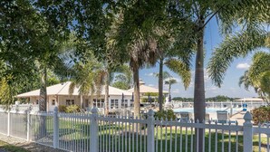 A fenced outdoor area with palm trees and a pool. - Lake Placid Home Boat Parking and Clubhouse Access by RedAwning (Lake Placid)
