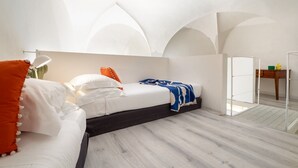 A modern bedroom with a bed, a desk, and a chair.