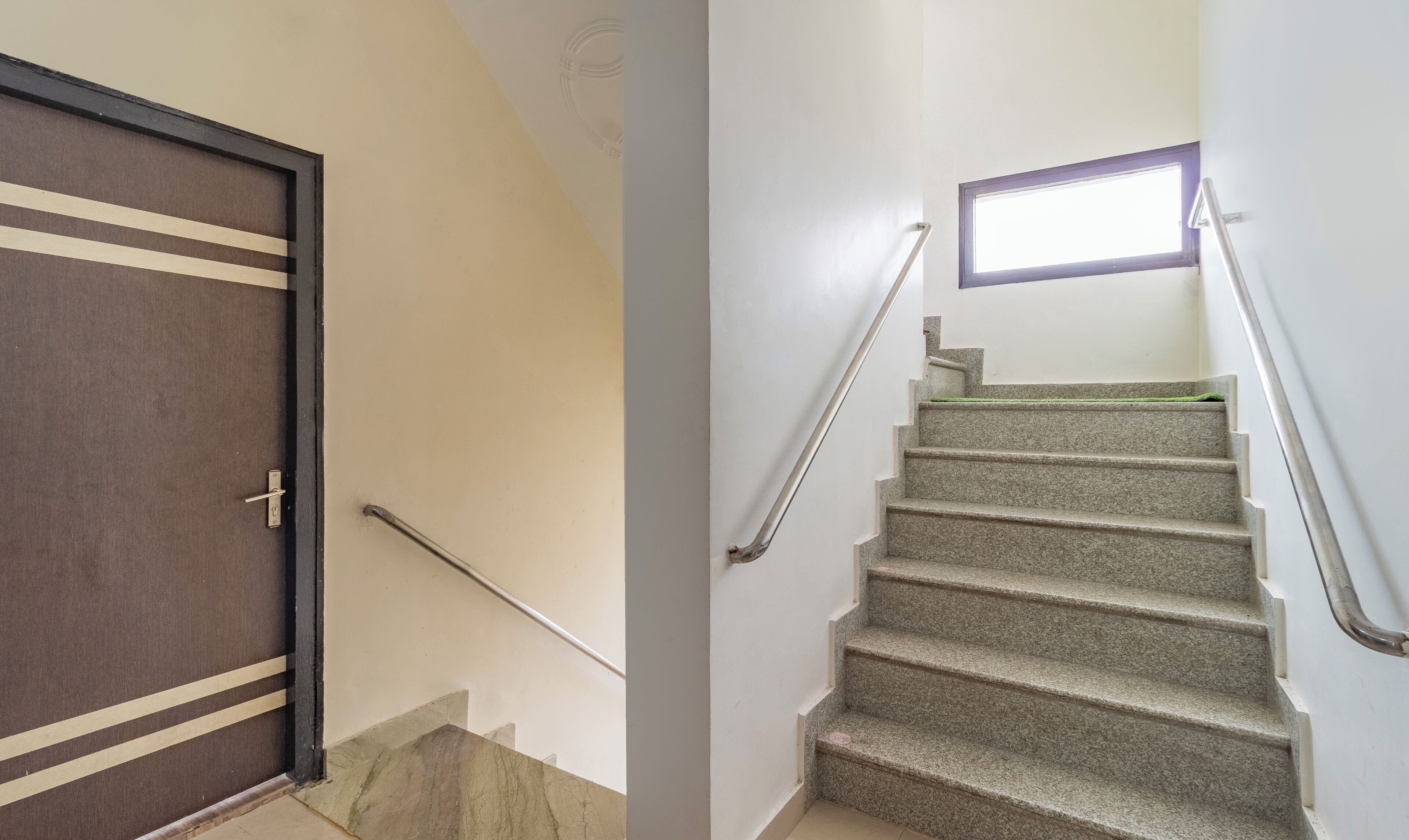 A staircase with a handrail and a door with a metal handle.
