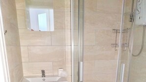 A modern bathroom with a glass-enclosed shower, a white sink, and a toilet. - Studio for 2 (ground floor) in fashionable North Shore (Blackpool)
