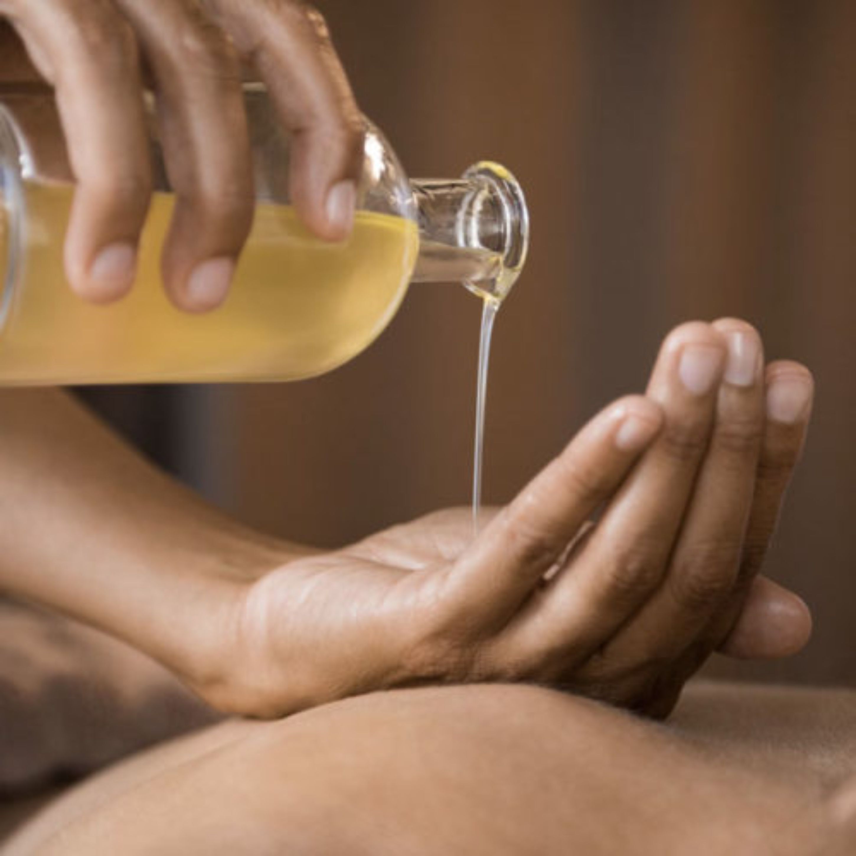 A person pouring a clear liquid onto their hands.