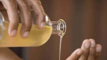 A person pouring a clear liquid onto their hands.