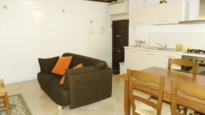A compact living space with a sofa, a dining table, and a kitchen area.