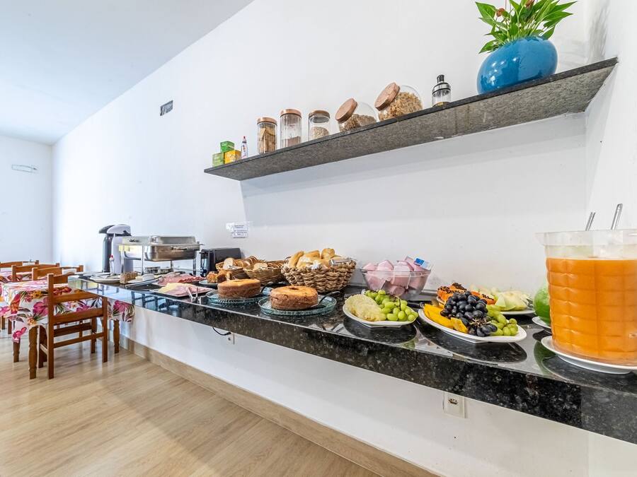 Um buffet de café da manhã com diversos alimentos e uma jarra de suco de laranja.