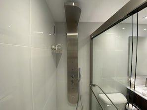 Ein modernes Badezimmer mit Glasdusche, Toilette und Waschbecken.
