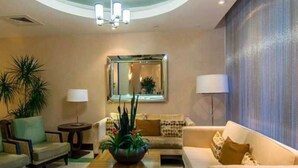 Un salón moderno con techo curvo, un espejo grande y una mesa de centro con plantas.