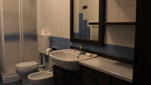 A bathroom with a toilet, bidet, sink, and mirror. - Lakefront apartment in downtown Stresa with magnificent views (Stresa)