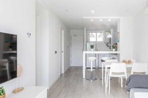Enjoy a stylish living space with a central dining area, kitchen, and cozy seating area.
