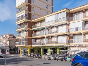 Stylish mid-century urban building with balconies and ground-level shops.