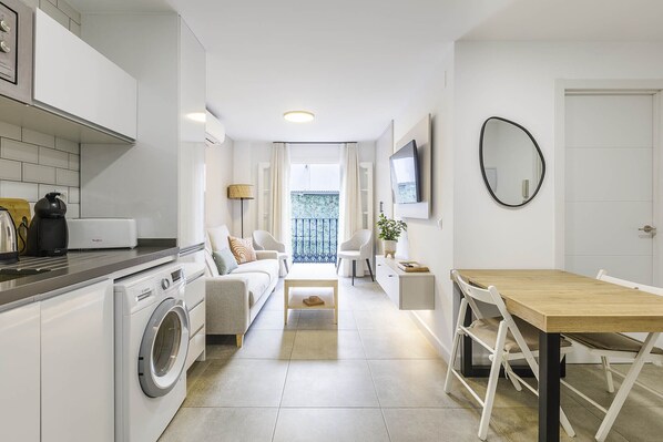 A compact apartment with a kitchen, dining area, and a living room.