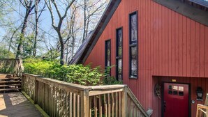 A red building with a wooden deck and a red door.