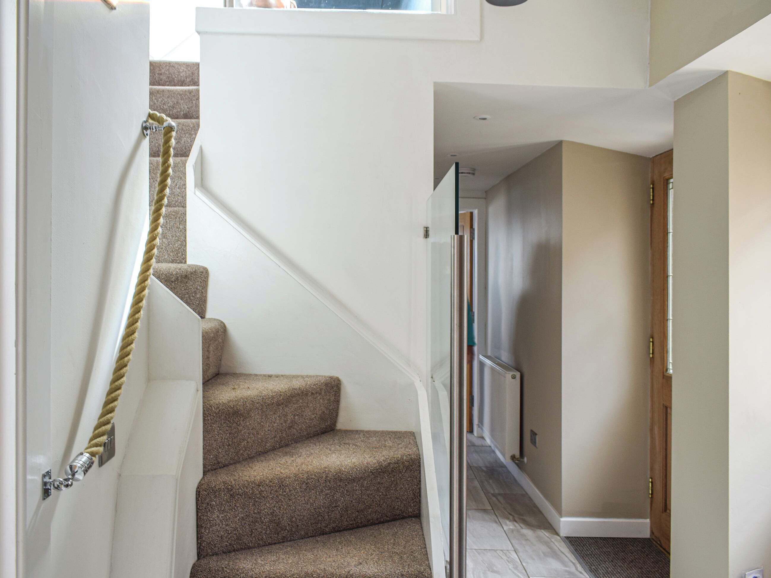 A staircase with carpeted steps leading to a landing.
