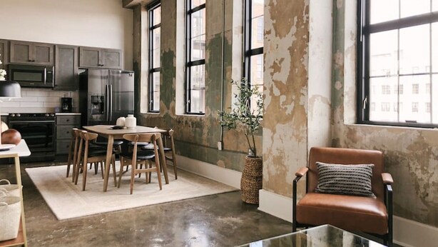 Een ruime keuken met moderne apparatuur, een eethoek met een tafel en stoelen, en een groot raam dat voor natuurlijk licht zorgt.