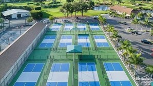 A tennis court complex with multiple courts, surrounded by a parking area and palm trees. - Perfect Naples golf and beach getaway! Just minutes from downtown and beaches. (Naples)