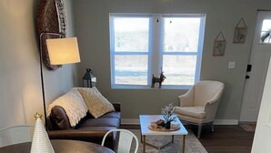 En matplats med ett runt bord, vita stolar, en brun lädersoffa, ett litet soffbord och en lampa.