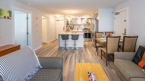 A modern apartment with a kitchen, dining area, and living room.