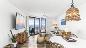 Una sala moderna con comedor, ventanas amplias y vista al océano.