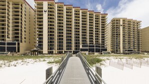 Un hotel de varios pisos con un atrio central, piscina al aire libre y acceso directo a la playa.