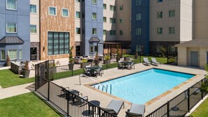 A modern hotel with a swimming pool, outdoor seating, and a well-maintained lawn. - Staybridge Suites Houston NW Cypress Crossings by IHG (Houston)