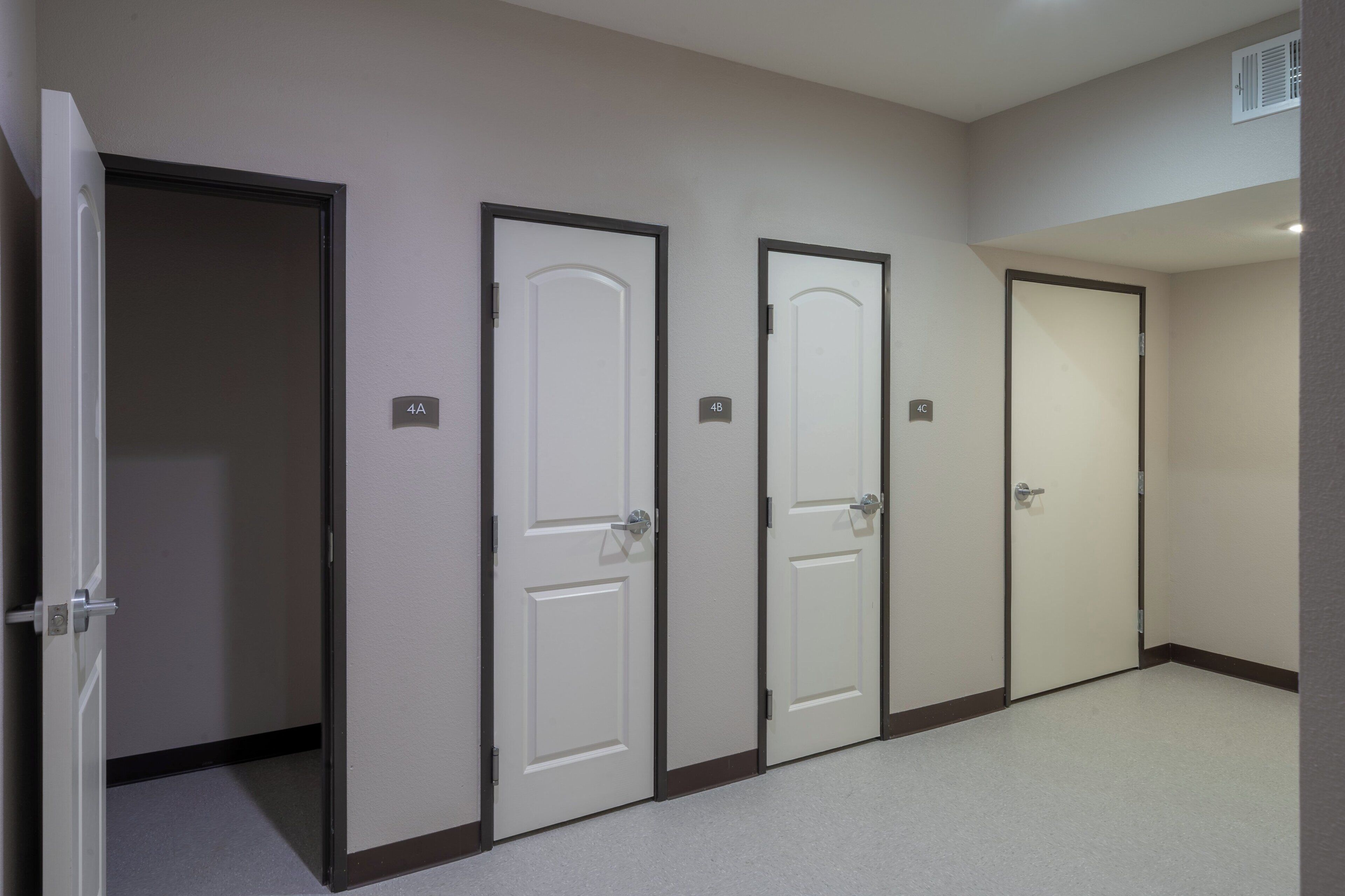 Um corredor com quatro portas, cada uma delas com um número.