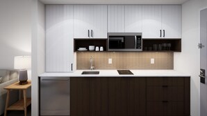 A modern kitchen with white cabinets, a microwave, and a sink. - Staybridge Suites Houston NW Cypress Crossings by IHG (Houston)