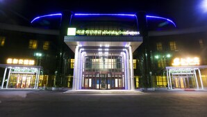 A Holiday Inn Express hotel entrance with illuminated signage and a glass facade. - Holiday Inn Express Harbin Exhibition Center by IHG (Harbin)