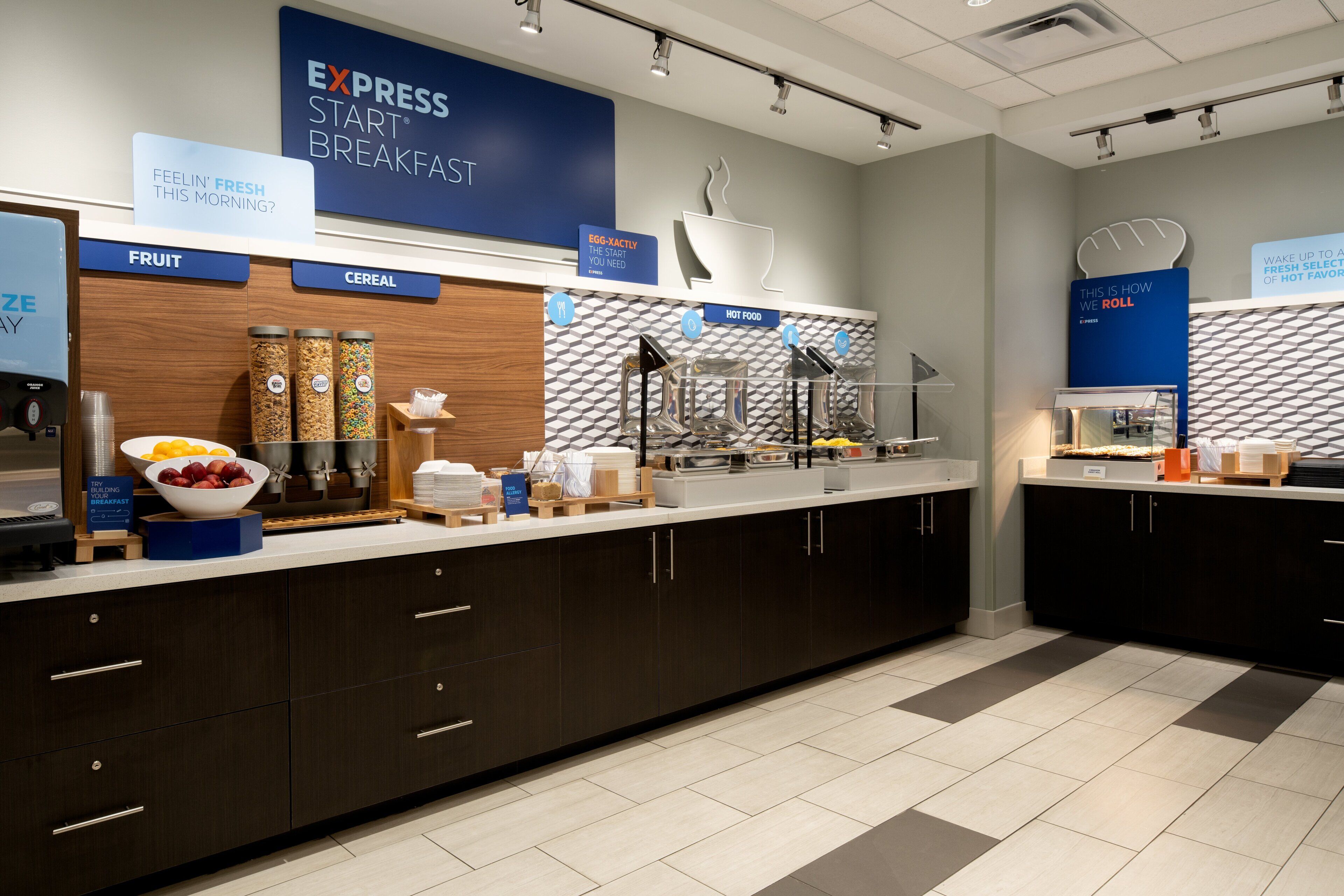 A modern breakfast area with labeled sections for fruit, cereal, and hot food.