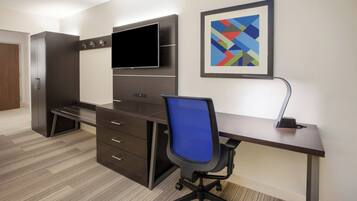 Un espacio de oficina moderno con un escritorio, una silla y un televisor de pantalla plana montado en la pared.