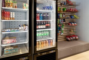 Een automaat gevuld met snacks en drankjes, waaronder ijs en frisdrank.