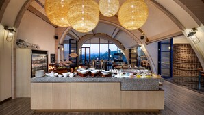 Una barra de desayuno de diseño moderno, con una isla grande que ofrece diversas opciones para el desayuno y vistas al exterior.