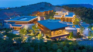 Un moderno complejo hotelero con varias construcciones, amplias ventanas y fachada bien iluminada.