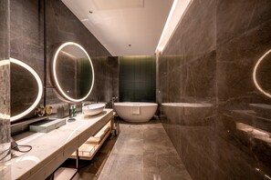 A modern bathroom with a freestanding bathtub, two sinks, and a vanity with a mirror. - Hotel Indigo Nanjing Garden Expo by IHG (Nanjing)
