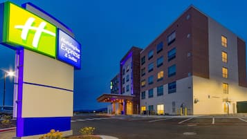 Hotel entrance with a flat roof and a mix of brick and stucco exterior.