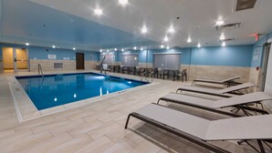 An indoor swimming pool with lounge chairs, ceiling lights, and a tiled floor. - Holiday Inn Express & Suites Harrisonburg University Area by IHG (Harrisonburg)